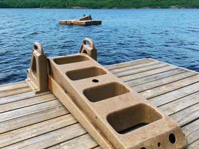 A 5 Step Dock Stairs is installed on a wooden dock by the lake, with another dock and stairs visible and trees along the distant shore.