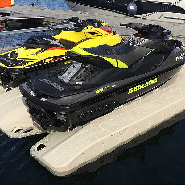 Two Sea-Doos are parked on docks featuring the Port Snap-in Cap by the water.