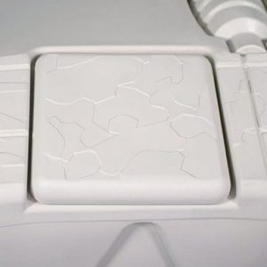 Close-up of the Port Snap-in Cap, featuring a cracked pattern on a light gray textured square panel.