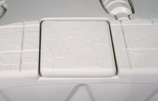 Close-up of the Port Snap-in Cap, featuring a cracked pattern on a light gray textured square panel.
