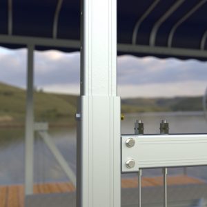Close-up of Boat Lift Canopies' metal frame on a dock by the water, with hills and a covered area blurred in the background.